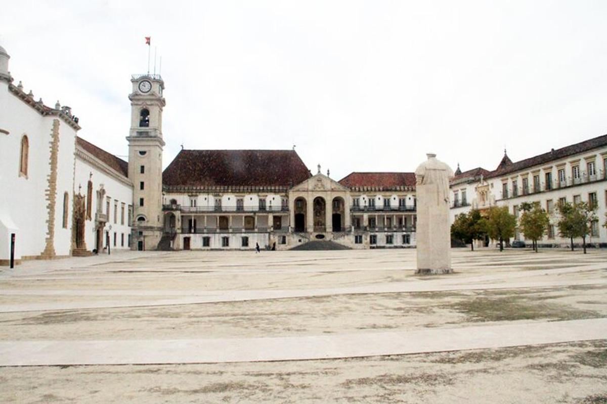 un grande edificio con una torre dell'orologio in un cortile