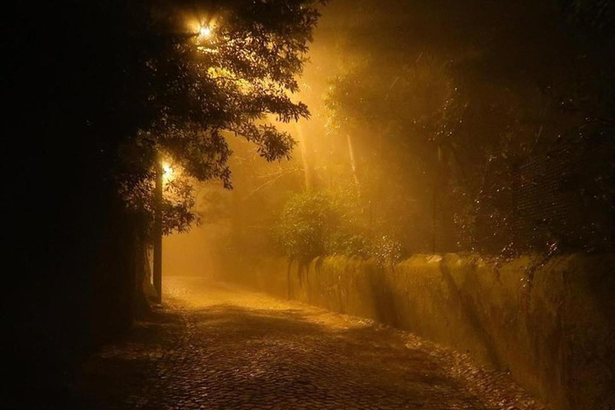 a foggy street at night with a street light