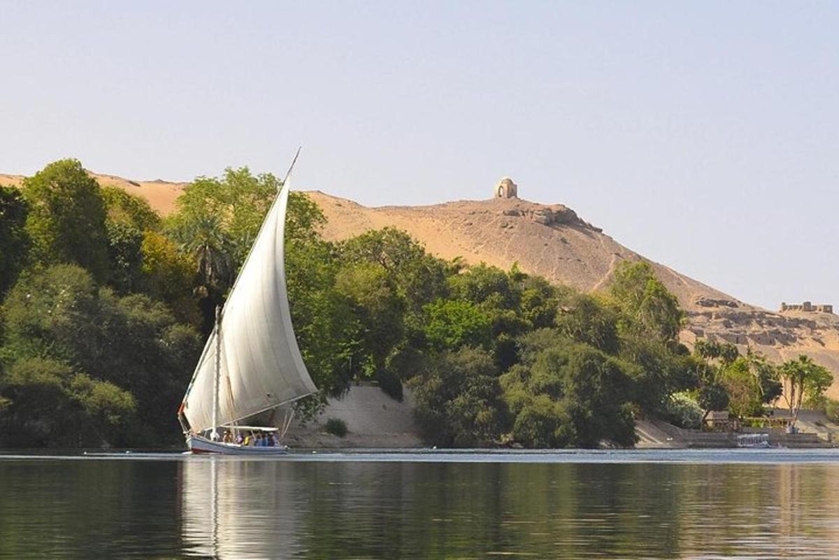 μια βάρκα με ένα μεγάλο άσπρο πανί στο νερό