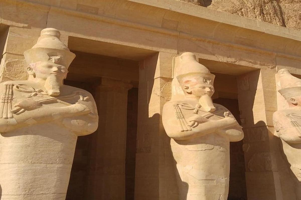 Dos estatuas de dos personas paradas frente a un edificio.