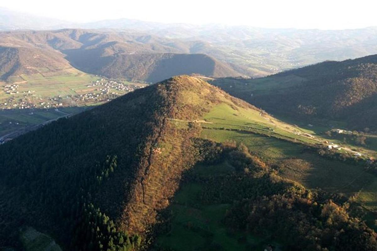 o vedere aeriană a unui munte cu păduri și munți