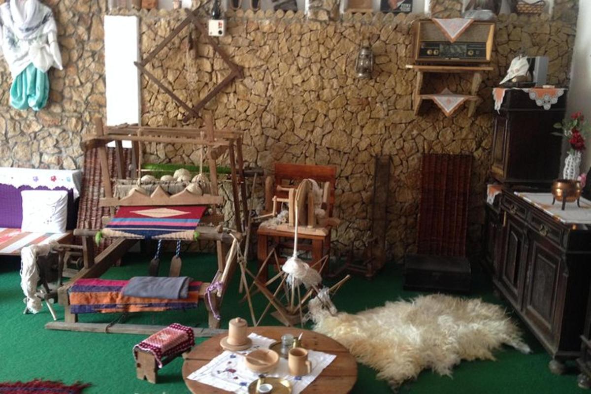 a room with a table and chairs and a stone wall