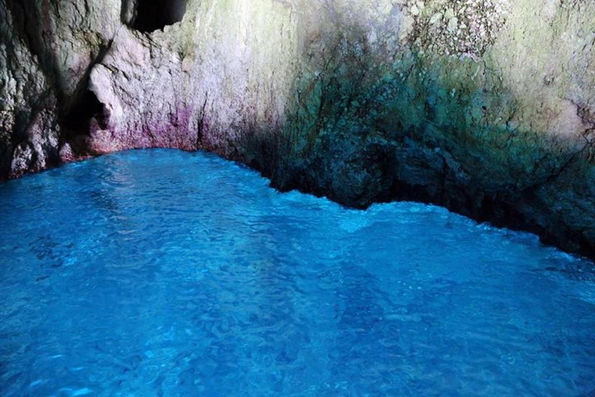 un dipinto di una pozza d'acqua blu in una grotta