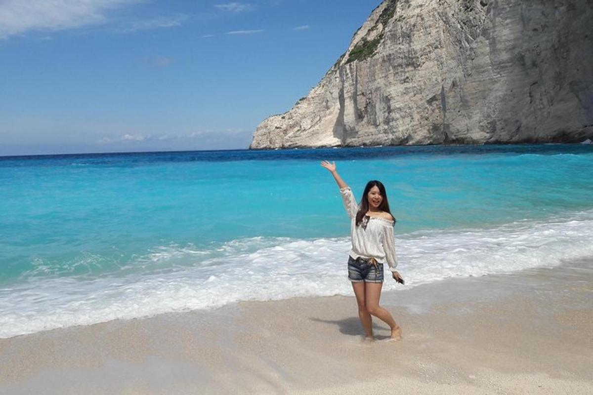 una donna in piedi su una spiaggia con la mano alzata in aria