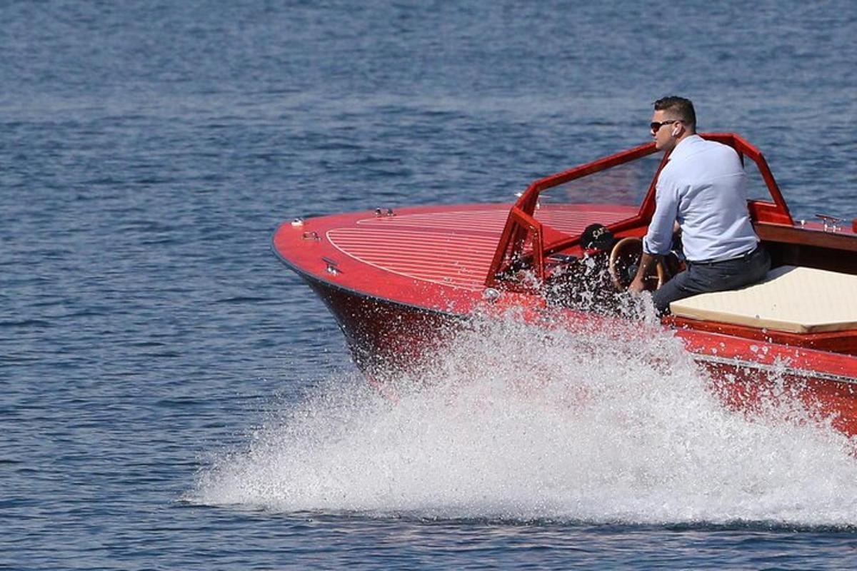 un uomo seduto su una barca rossa nell'acqua