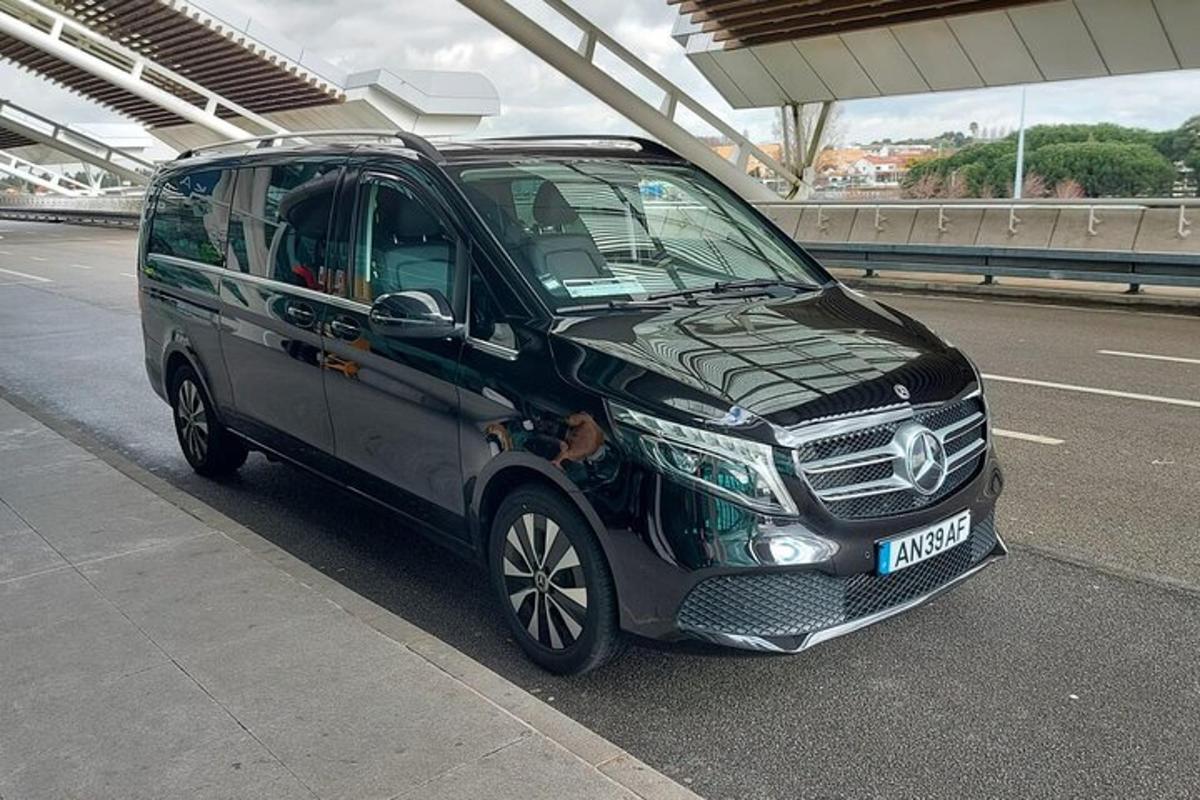 en liten svart varebil parkert ved siden av en vei