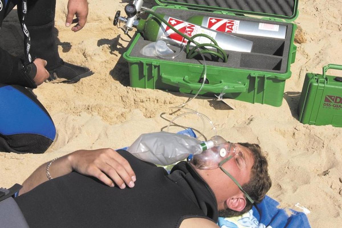 een man die in het zand op het strand ligt