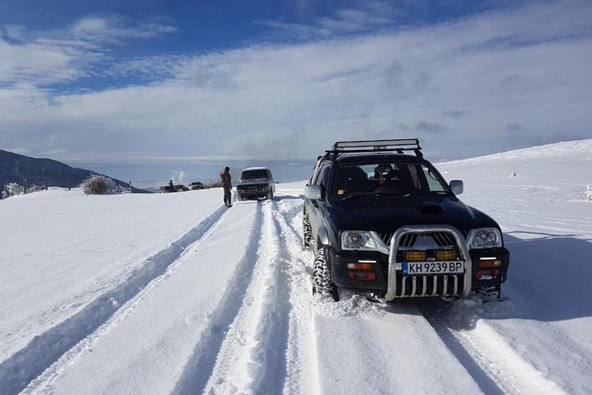 a suv parked in the snow on a snow covered road