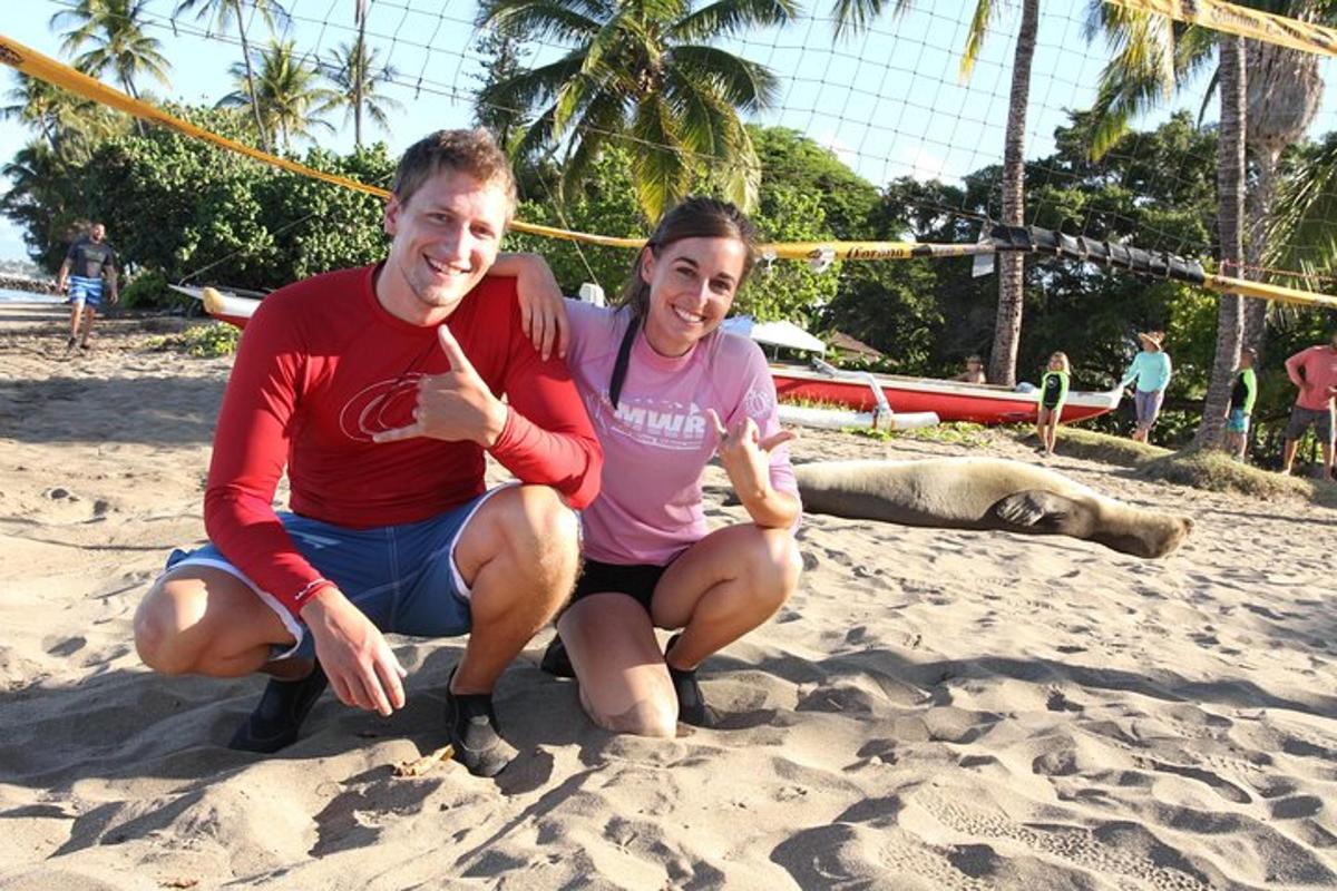 a man and woman giving the thumbs up on the beach