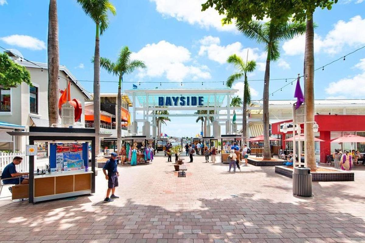 Un centro comercial con palmeras y gente paseando.