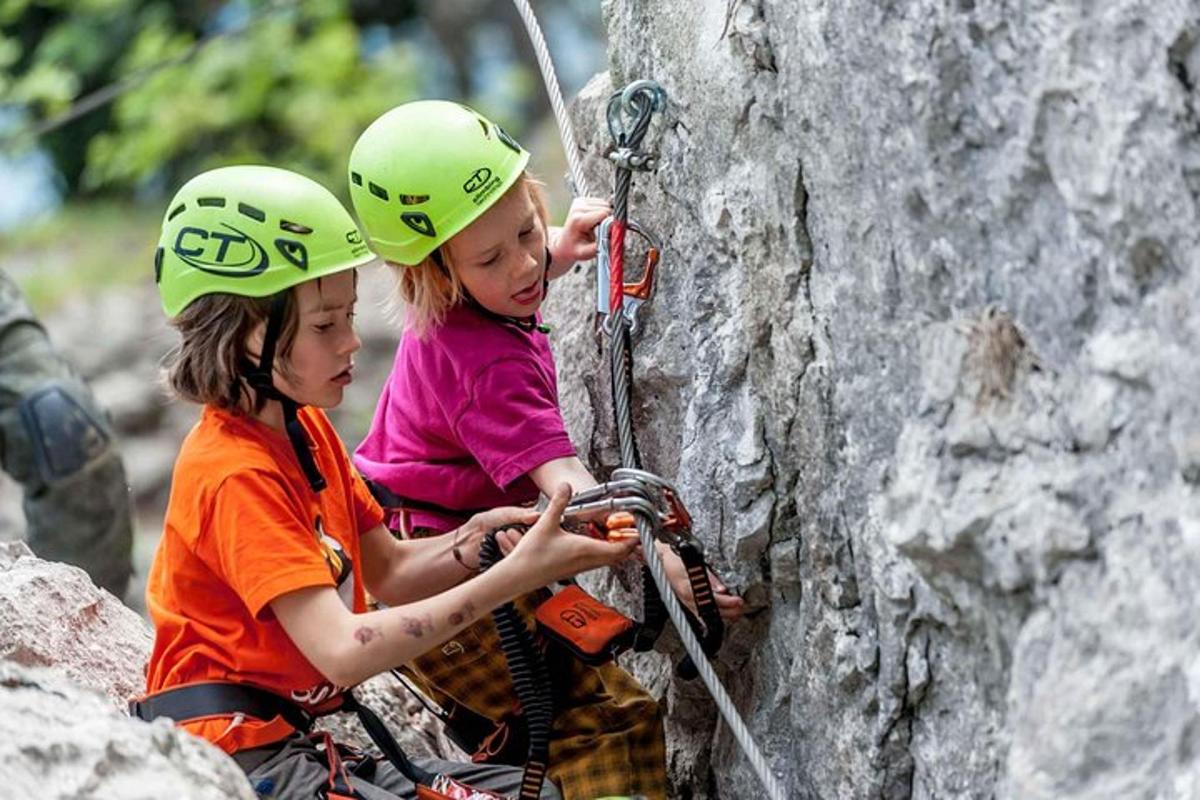 two children are climbing on a rock wall