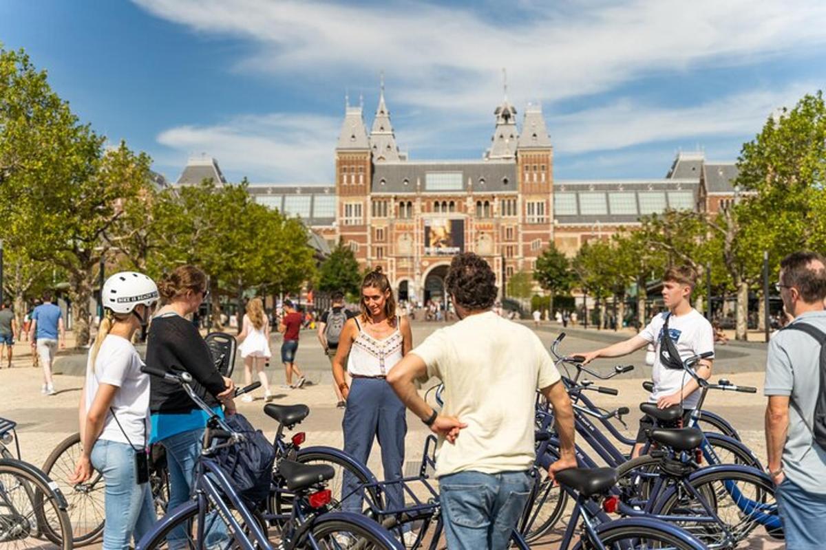 a group of people standing with bikes in front of a building