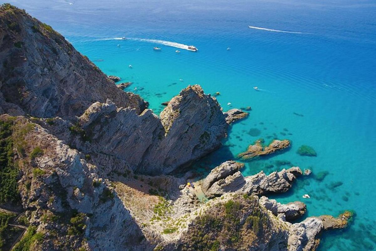 una vista aerea di una costa rocciosa con acqua blu