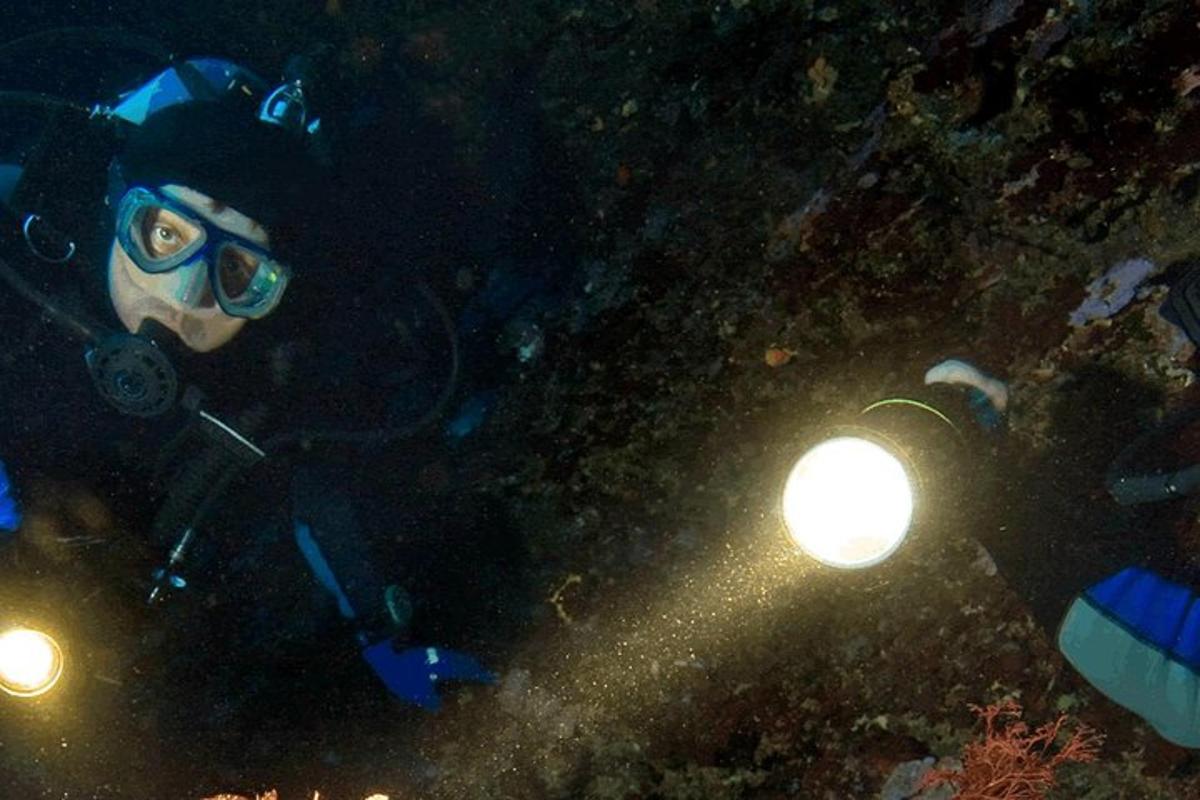 a person in a diving suit with lights in the dark