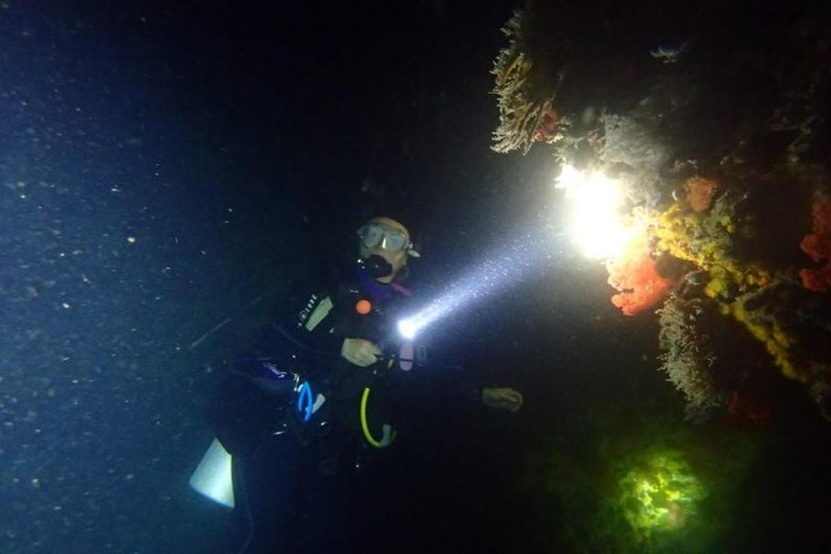 a person holding a flashlight in the dark
