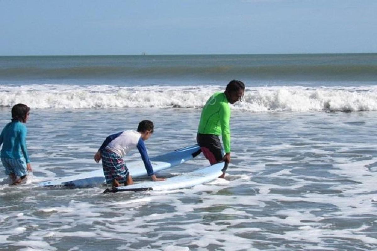 un gruppo di persone in piedi nell'oceano con tavole da surf