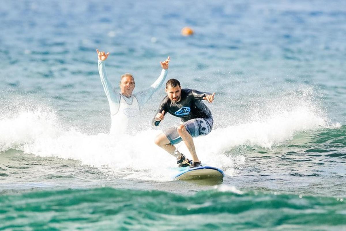 due persone cavalcano un'onda su una tavola da surf nell'oceano