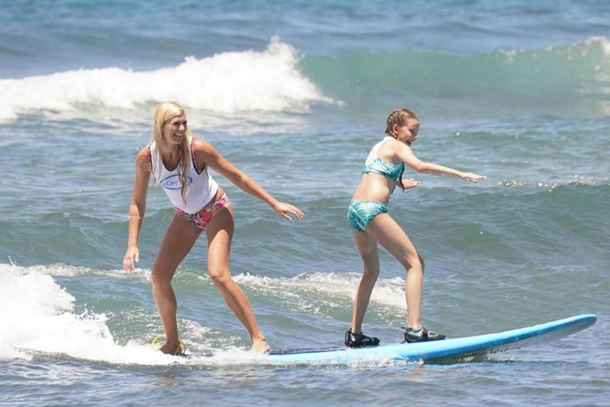 due ragazze in costume da bagno su una tavola da surf nell'oceano