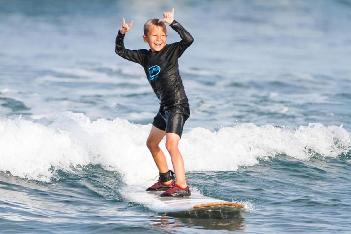 un ragazzino che cavalca un'onda su una tavola da surf nell'oceano