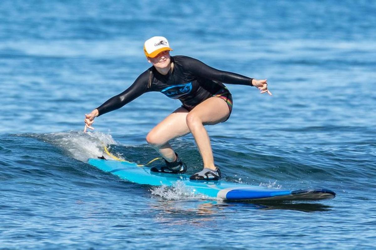 en kvinne som rir på en bølge på et surfebrett i vannet