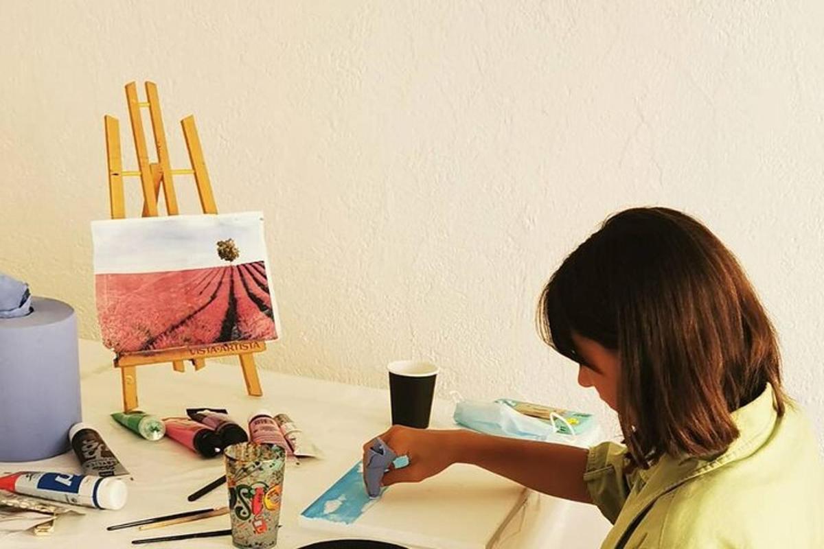 uma jovem está fazendo uma pintura sobre uma mesa