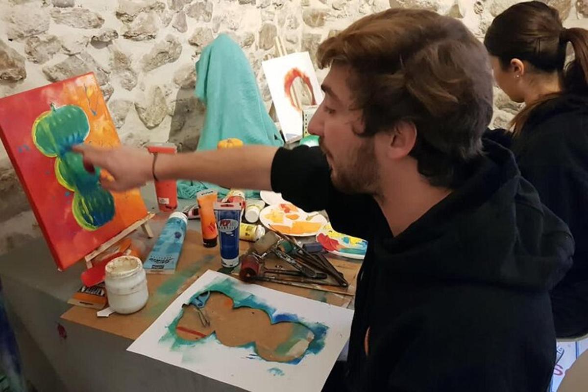 maður er að mála málverk á striga