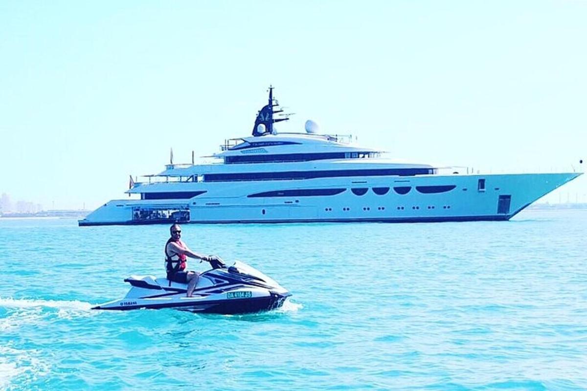 un uomo in moto d'acqua davanti a un grande yacht
