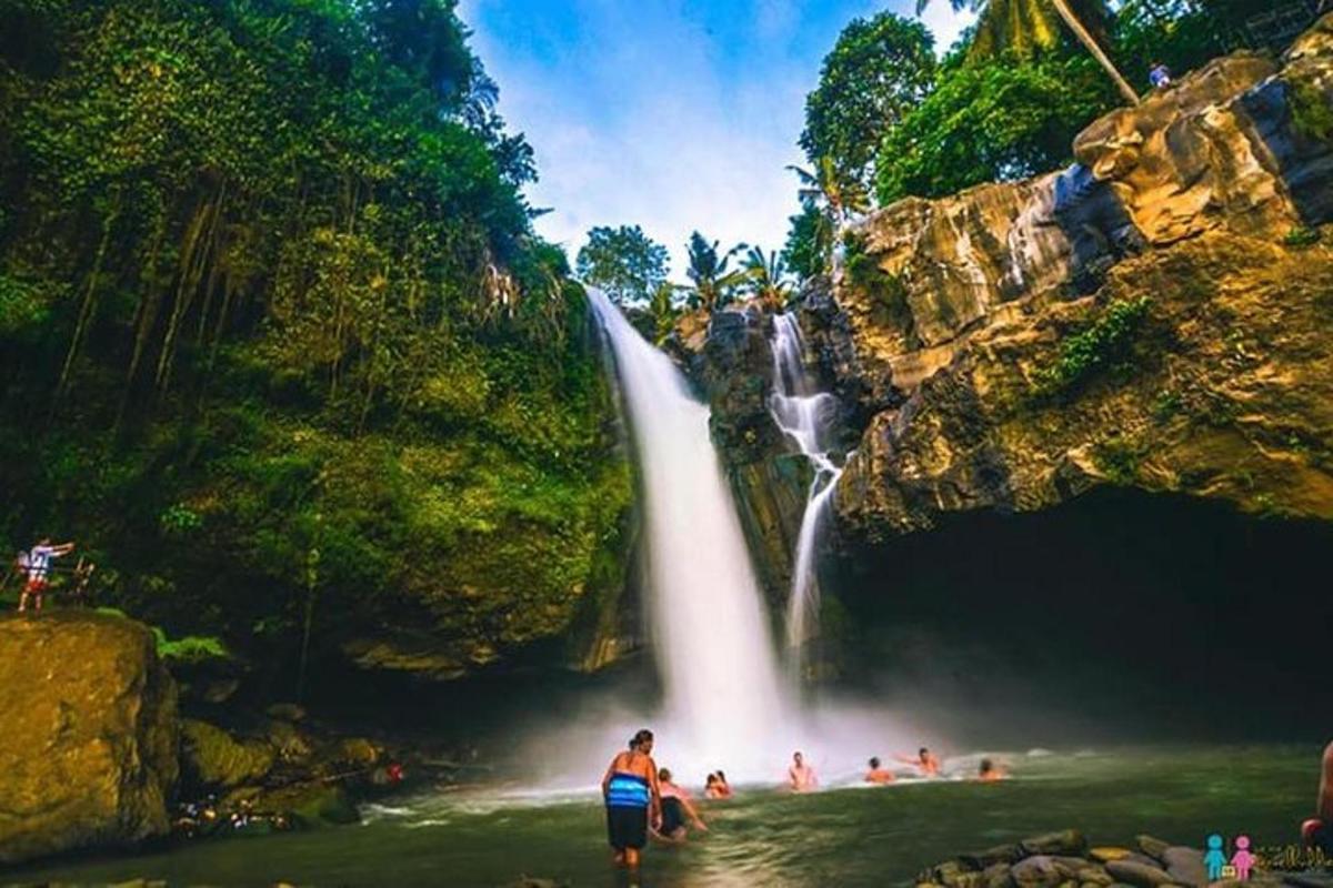 un gruppo di persone in piedi davanti a una cascata