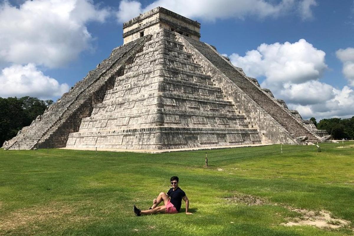 un uomo seduto sull'erba davanti a una piramide