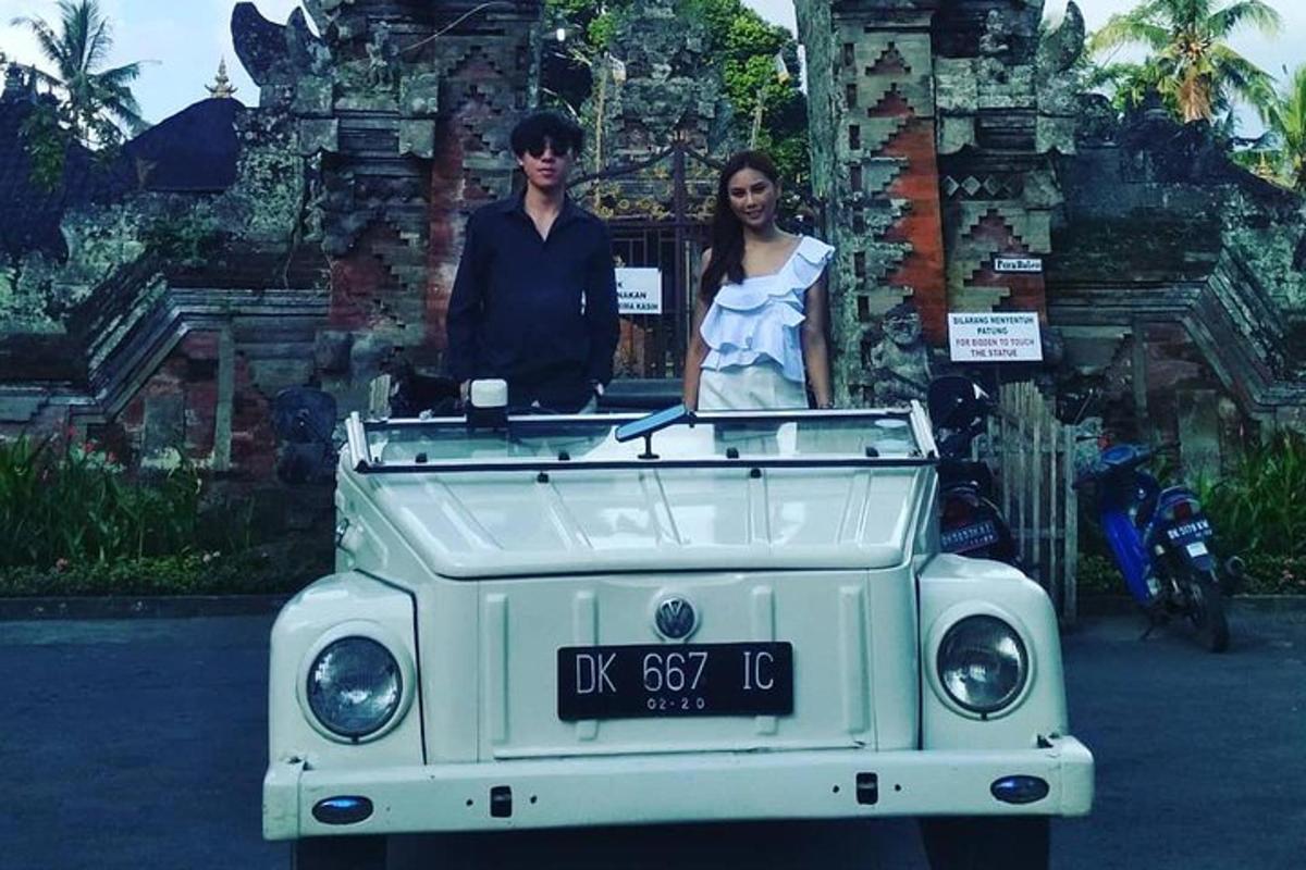 a man and woman standing in the back of a white jeep