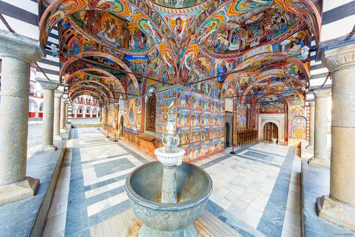 una habitació amb una font en un edifici amb sostres pintats