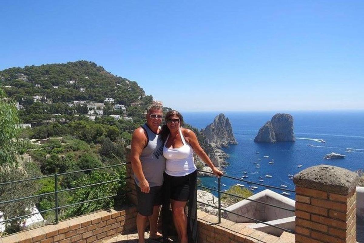 un uomo e una donna in piedi su una sporgenza che domina l'oceano