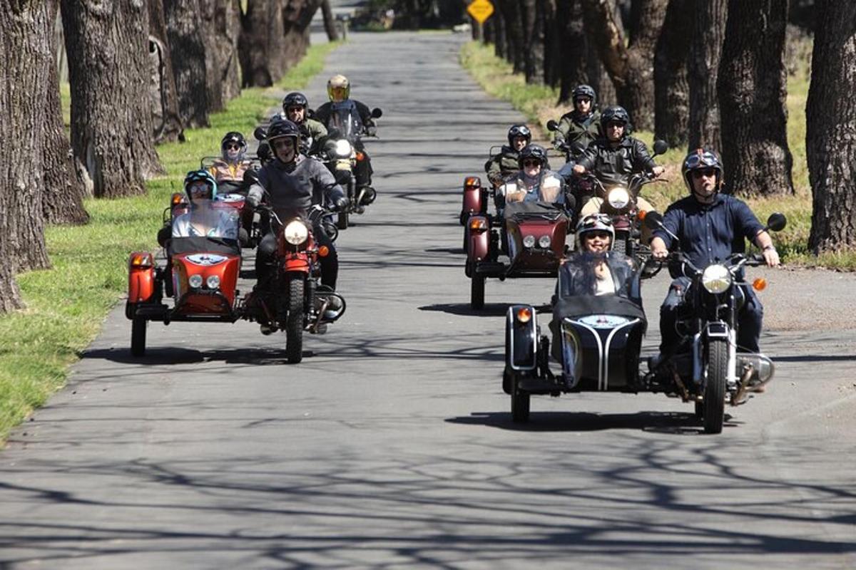 cilvēku grupa, kas brauc ar motocikliem pa ceļu
