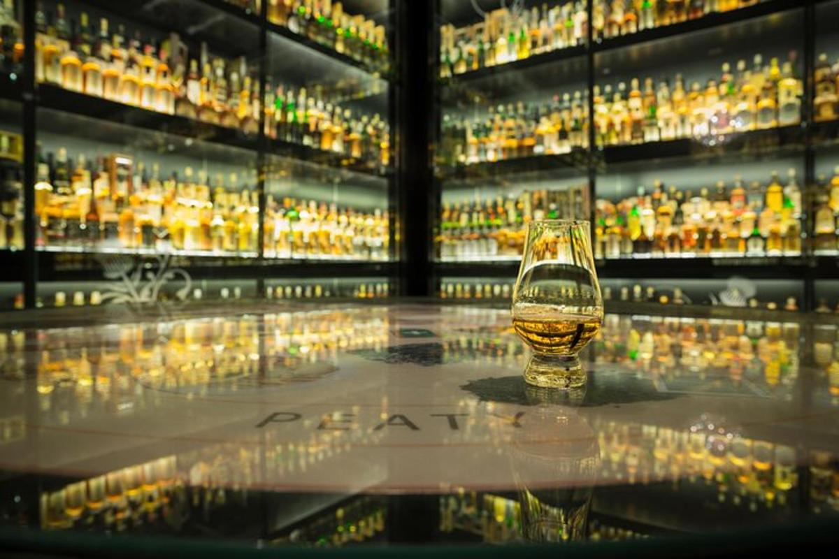 segelas wiski di hadapan paparan alkohol