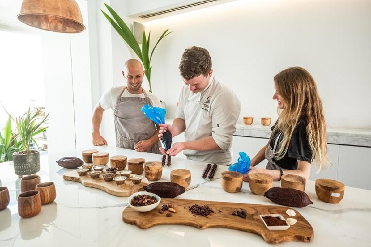 a group of three people in a kitchen preparing food