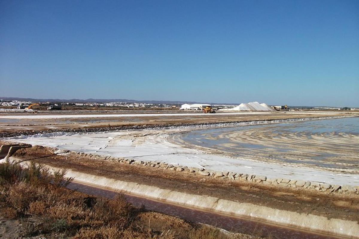 a large dirt field with a body of water
