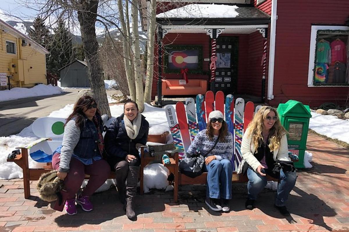 Un grupo de mujeres sentadas en sillas frente a una casa.