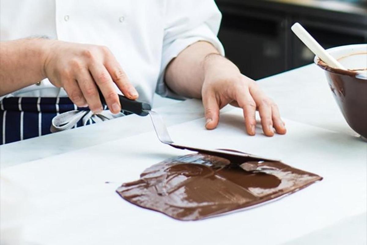 a person cutting a piece of chocolate on a counter