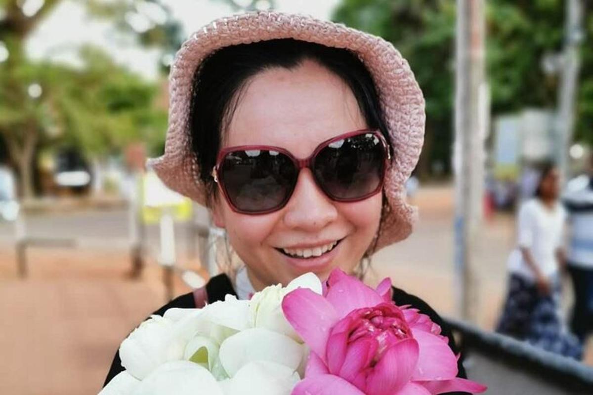 一位戴着太阳镜、手捧花束的女士