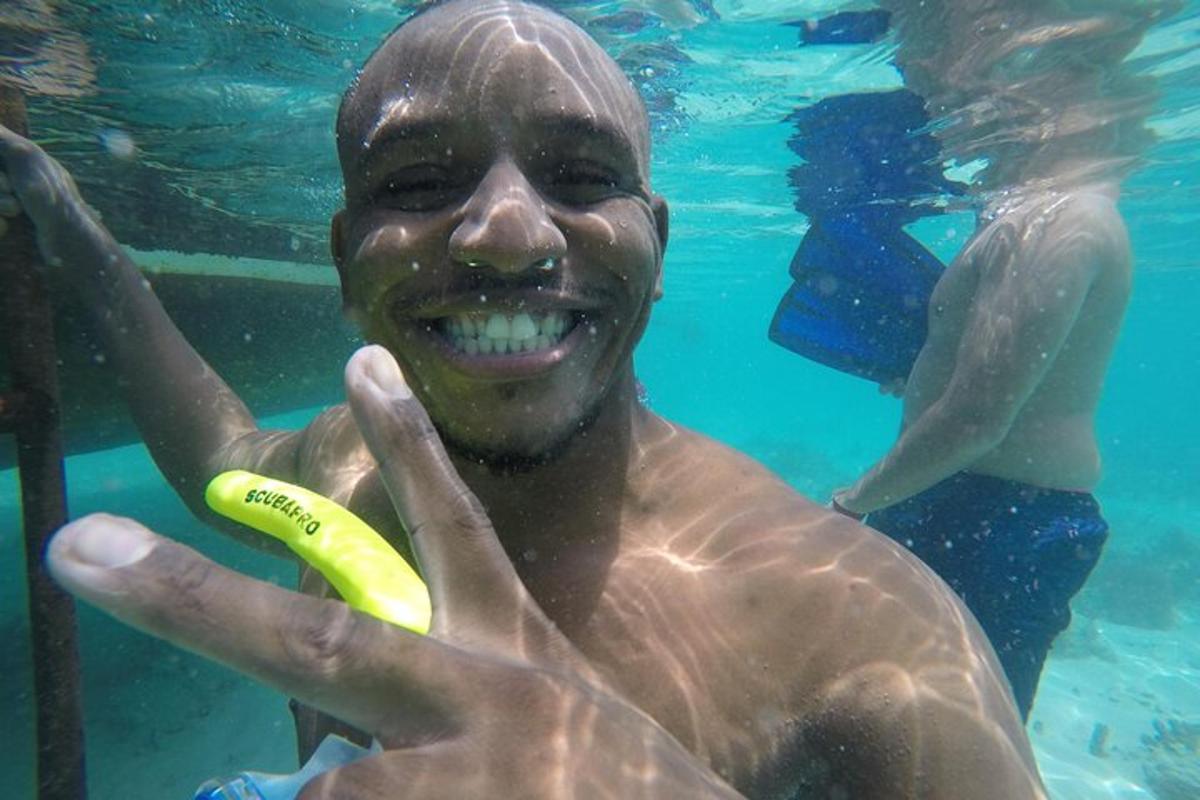 a man in the water holding a yellow frisbee