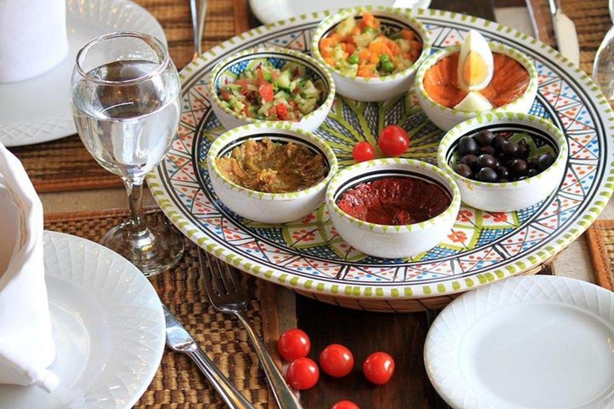 a table with a plate of food and glasses of wine