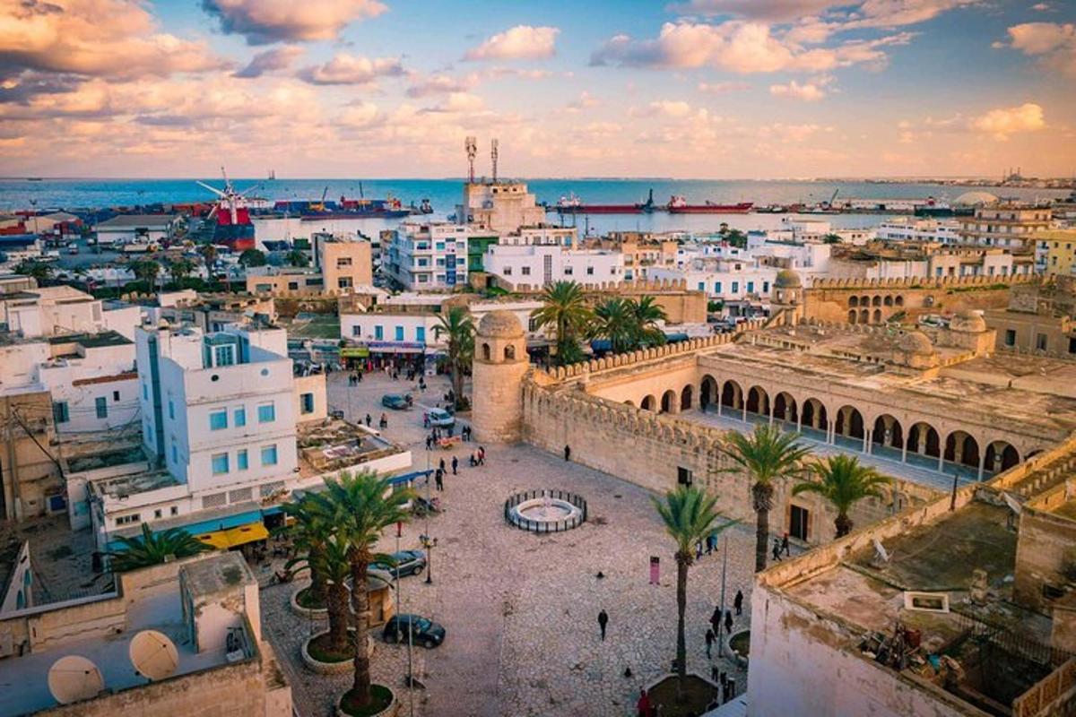 a city with buildings and palm trees and the ocean