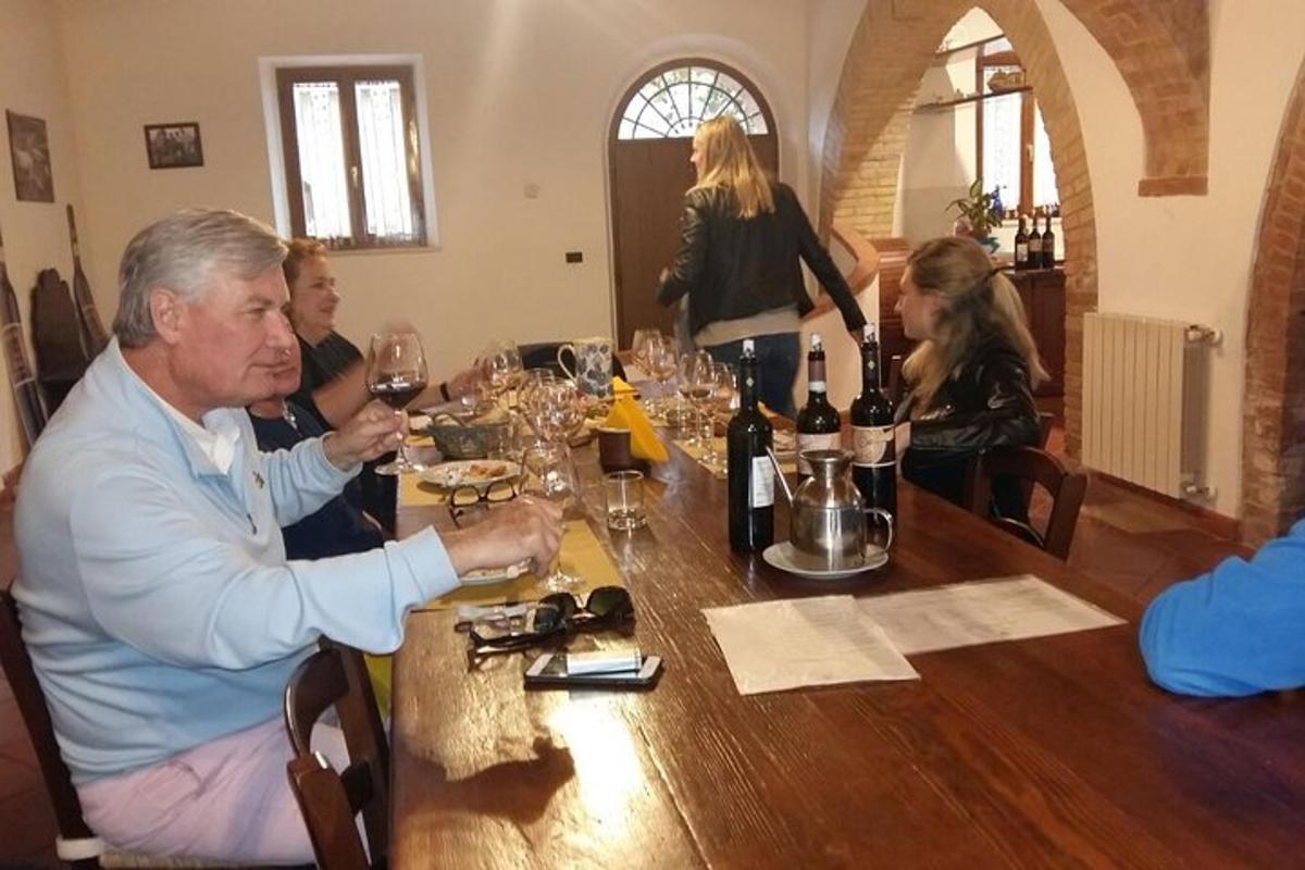 un grup de persones assegudes al voltant d'una taula amb copes de vi