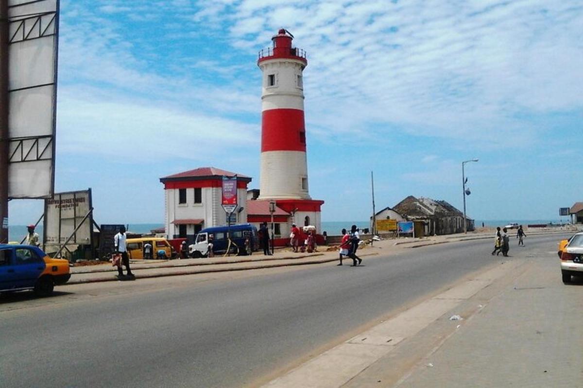 a red and white lighthouse on the side of a road