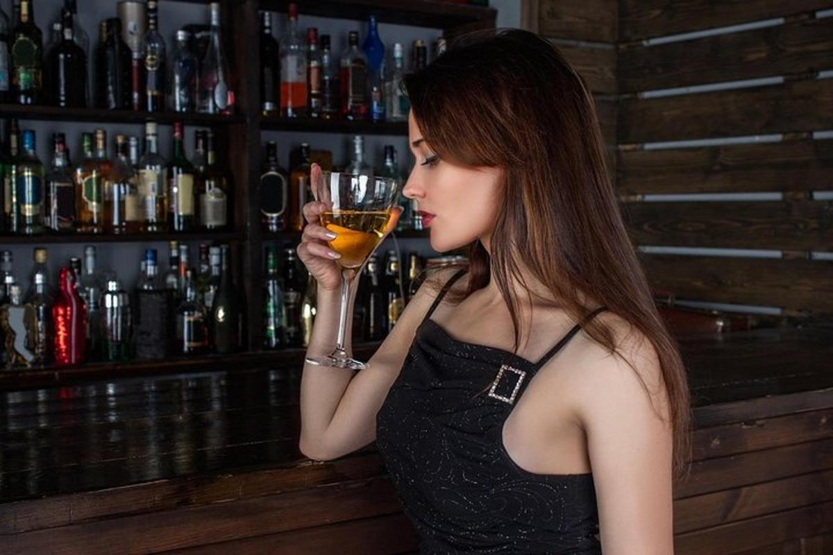 ženska, ki drži kozarec vina v baru