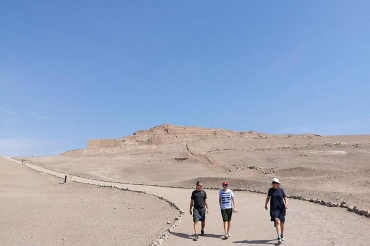 três pessoas caminhando por um caminho no deserto