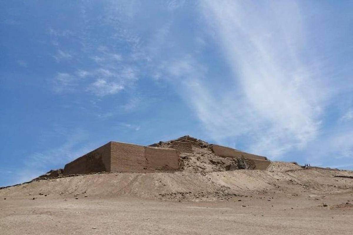 a mound of sand in the middle of a field