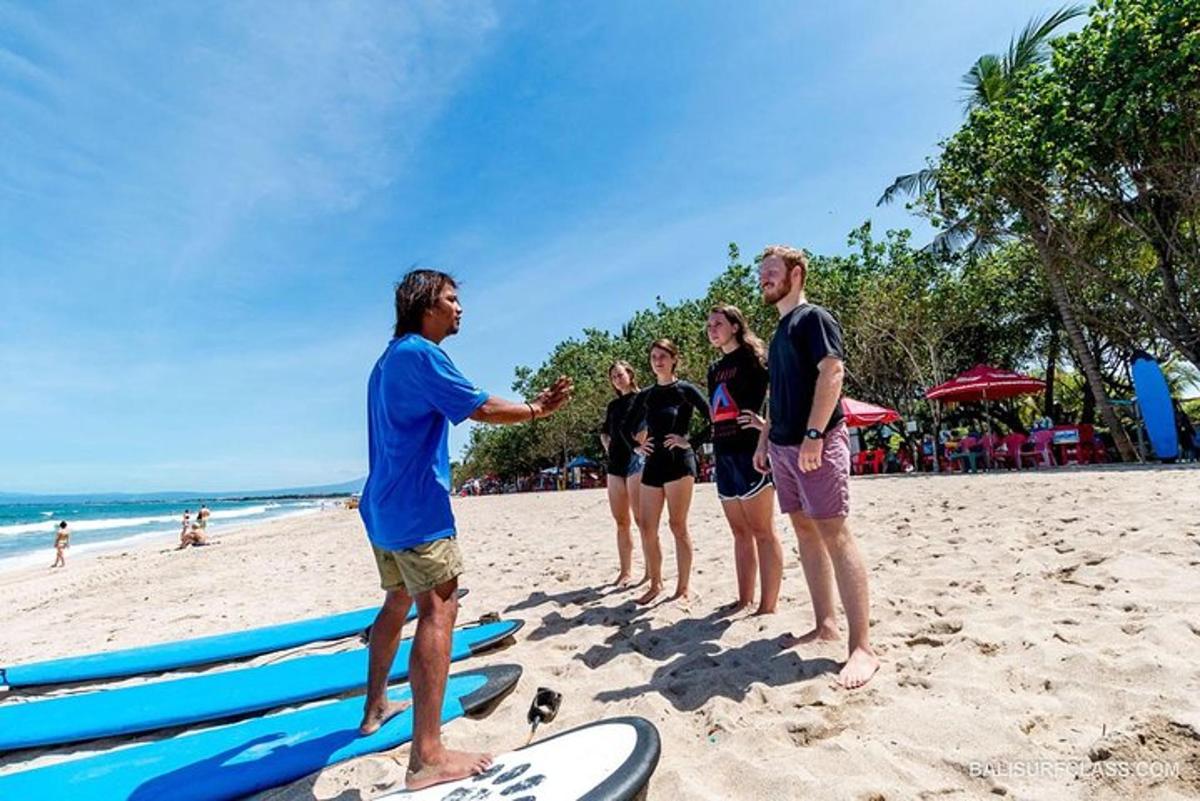 Un grupo de personas de pie en una playa con tablas de surf.