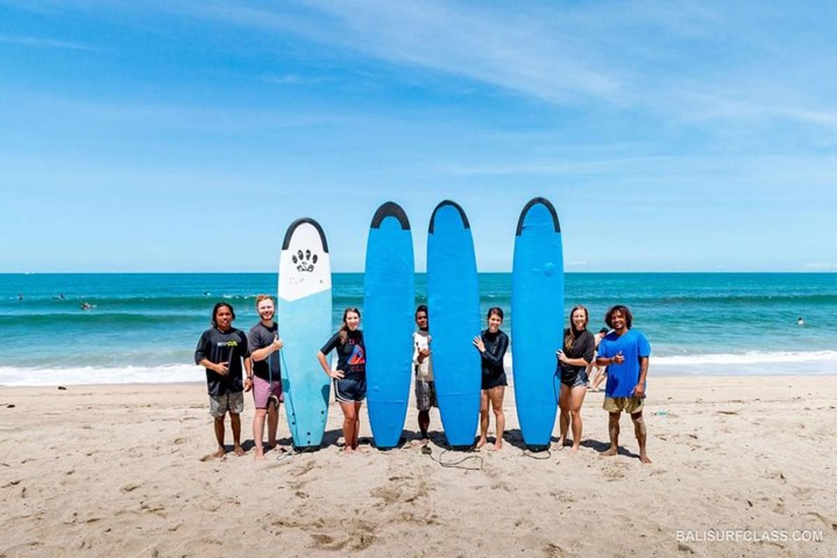 Un grupo de personas de pie frente a tablas de surf en la playa.