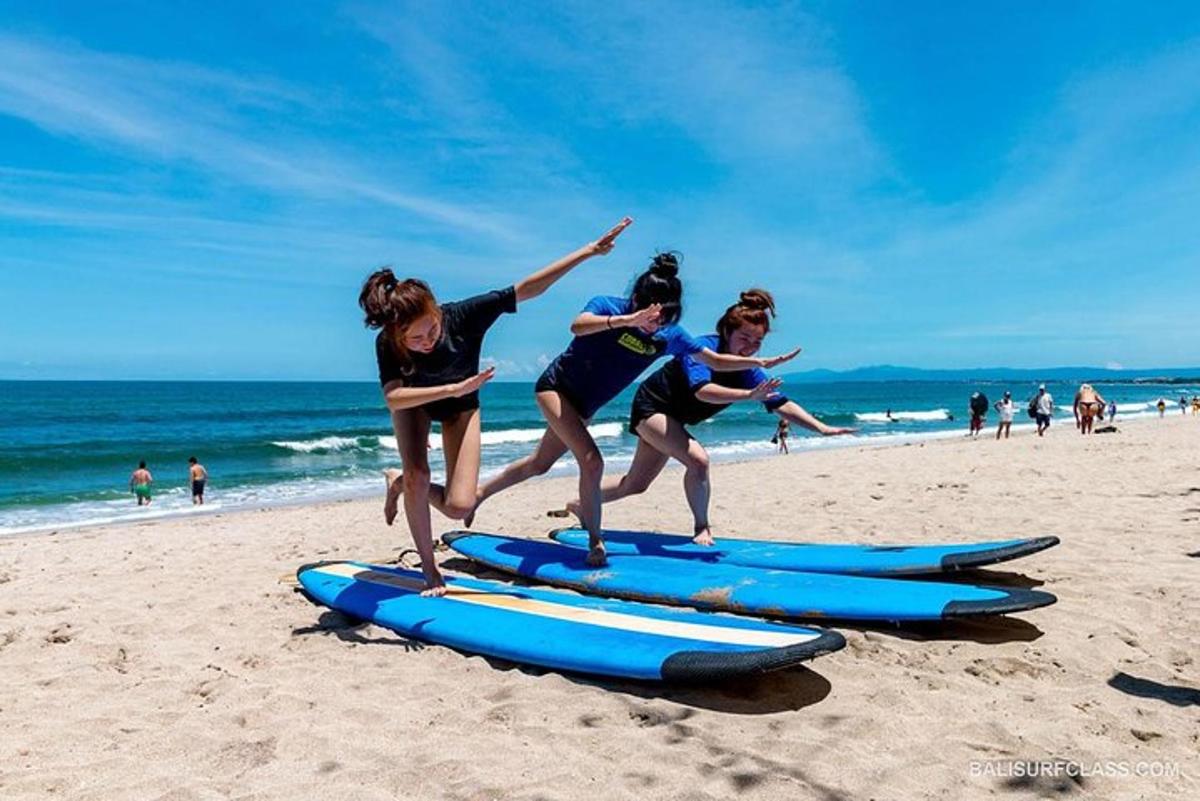 trzy dziewczyny skaczące na deskach surfingowych na plaży